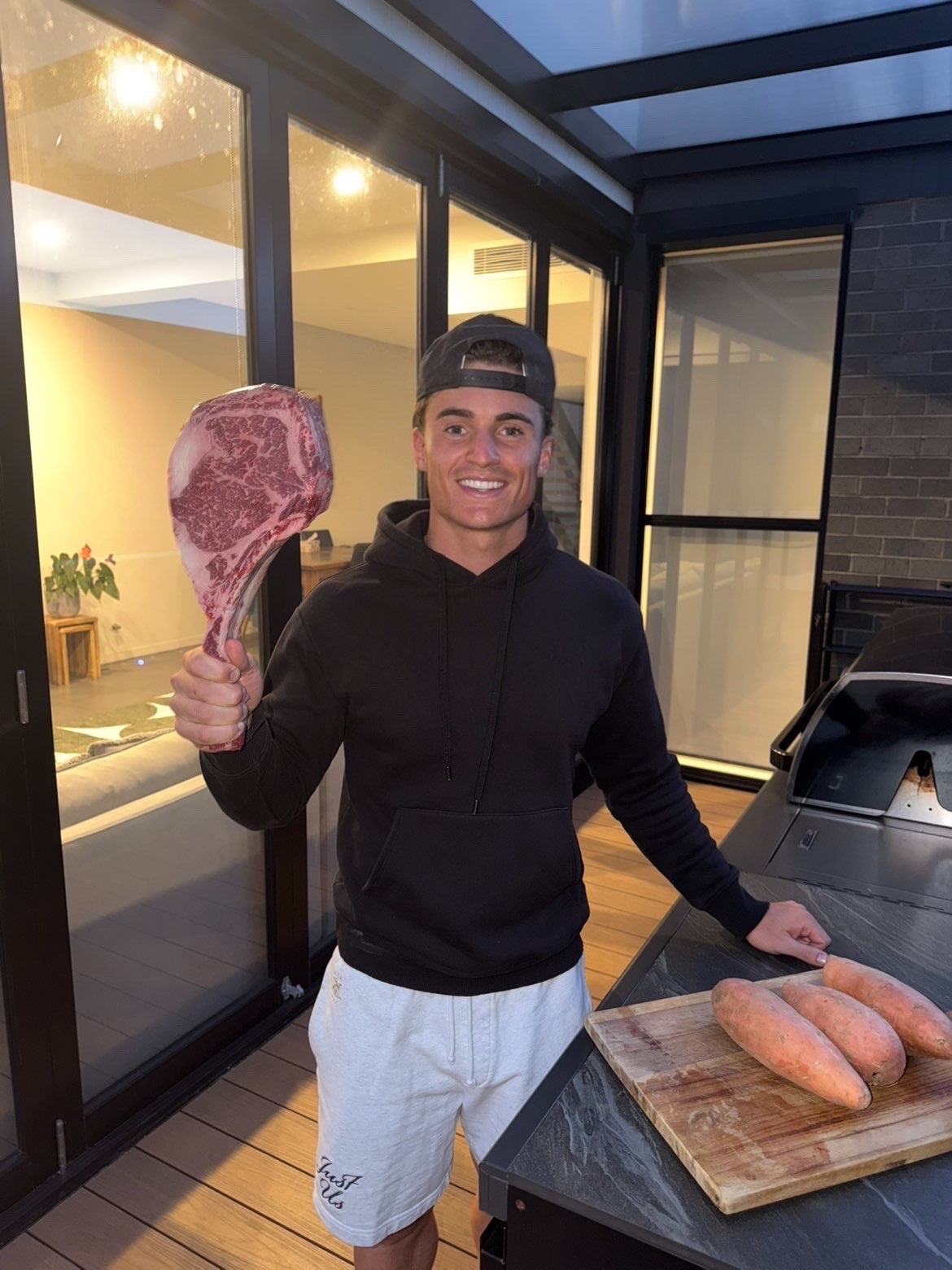 Zac holding a tomahawk steak